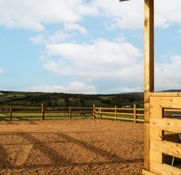An outdoor space with a gravel area and a wooden fence at Glenview Log Cabin in Ballycastle