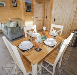 A dining room with a table and chairs at Glenview Log Cabin Ballycastle