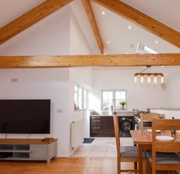 A kitchen and dining area with a table and chairs at The Maisonette in Hayle
