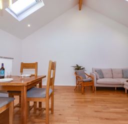 A living room with a table, chairs, and a couch at The Maisonette in Hayle