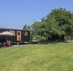 A cabin with a patio and furniture in an outdoor area at Dave’s Place Broadstone near Munslow