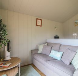 A living room with a sofa and coffee table at Leafy Oaks Cabin in Munslow