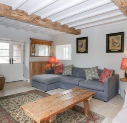 A living room with a sofa and coffee table at Velindra Farm Cottage in Hereford
