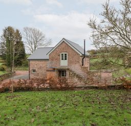 A house with a stone exterior and stairs leading to the door at Velindra Farm Cottage in Hereford