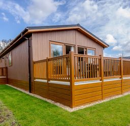 An outdoor cabin with a deck and fenced area at The Alwalton in Kings Cliffe