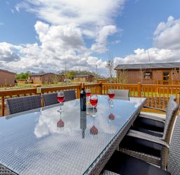 An outdoor seating area with a table and glasses at The Alwalton in Kings Cliffe