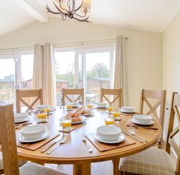 A dining room with a round table and plates at The Alwalton in Kings Cliffe