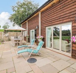 A garden with deck chairs and a dining table at Lake View in Crediton