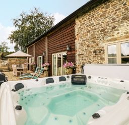 An outdoor area with a hot tub and seating at Lake View in Crediton