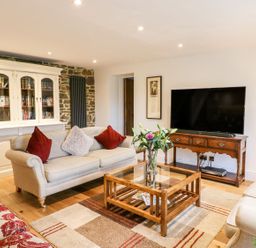 A living room with a sofa and television at Lake View in Crediton