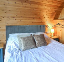 A bedroom with a bed and lamp at Garden Lodge 4 Swansea