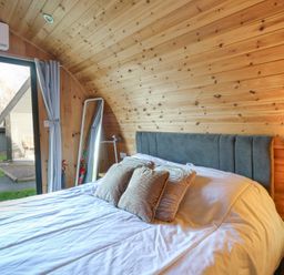 A bedroom with a bed and mirror at Garden Lodge 4 in Swansea