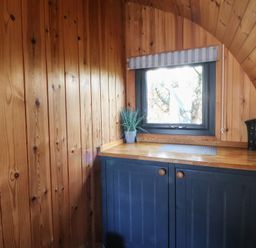 A kitchen with wooden walls and a kettle in Garden Lodge 4 Swansea