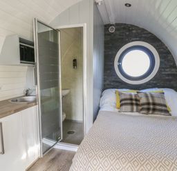 A bedroom with a bed and shower at Garden Lodge 9 in Swansea