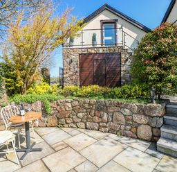 A garden with a table and chair at Rose Apartment, Old Walls, Llanrhidian, Gower