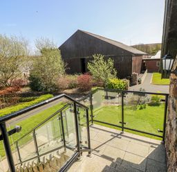 An outdoor area with a balcony overlooking buildings at Willow Apartment in Oldwalls, Llanrhidian, Gower