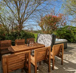 An outdoor area with a wooden table and chairs at Ivy Cottage Oldwalls, Llanrhidian, Gower