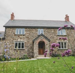 A house with stone walls and windows in the garden at Knowle House Okehampton