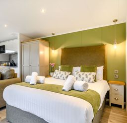 A bedroom with a bed and a couch at Pear Tree Spa (Pet) Carlton Miniott near Thirsk