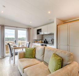 A living room with a sofa and dining area at Pear Tree Spa (Pet) Carlton Miniott near Thirsk