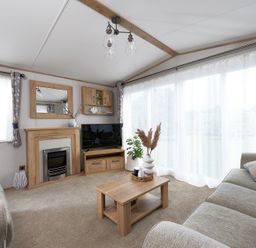A living room with a television and coffee table at Juniper Waterside Spa Carlton Miniott near Thirsk