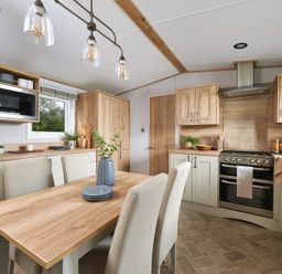 A kitchen with dining table and chairs at Juniper Waterside Spa Carlton Miniott near Thirsk
