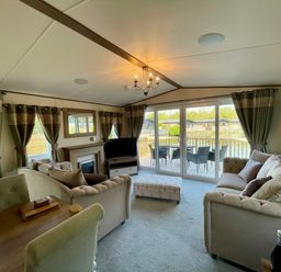 A living room with a sofa and television at Acacia Waterside Spa, Carlton Miniott near Thirsk
