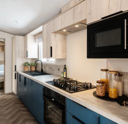A kitchen with sink and stove at Rowan Waterside Spa Carlton Miniott near Thirsk
