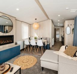 A living room with a couch and dining table at Rowan Waterside Spa Carlton Miniott near Thirsk
