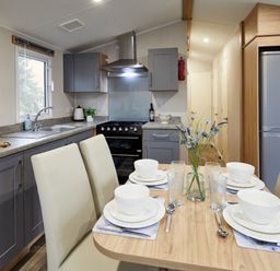 A kitchen with a dining table and chairs at Banyan Waterside Spa Carlton Miniott near Thirsk