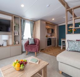 A living room with a television and kitchen area at Ellery Waterside Spa Carlton Miniott near Thirsk