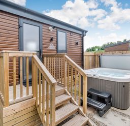 An outdoor area with a hot tub and wooden stairs at Cedar Spa Carlton Miniott near Thirsk