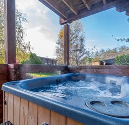 A hot tub surrounded by wooden structure at Birch Waterside Spa (Pet) Carlton Miniott near Thirsk