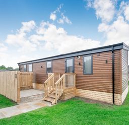 An outdoor view of a wooden cabin with steps at Cedar Spa (Pet) Carlton Miniott near Thirsk
