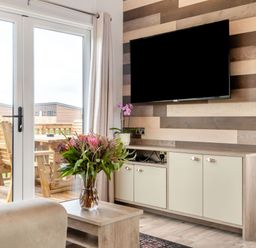 A living room with a TV and cabinets at Kinder Spa (Pet) Carlton Miniott near Thirsk