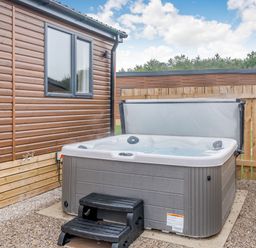 A hot tub with steps beside a wooden fence at Spindle Spa (Pet) Carlton Miniott near Thirsk