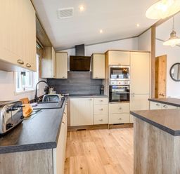 A kitchen with cabinets and appliances at Spindle Spa (Pet) Carlton Miniott near Thirsk