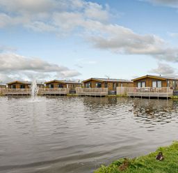 A view of lodges by the water at Larch Waterside Spa Carlton Miniott near Thirsk