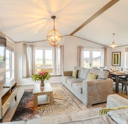 A living room with a sofa and dining area at Beech Waterside Spa Carlton Miniott near Thirsk