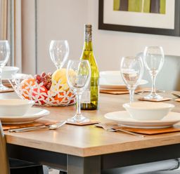 A dining table set with a wine bottle and fruit bowl at Beech Waterside Spa Carlton Miniott near Thirsk