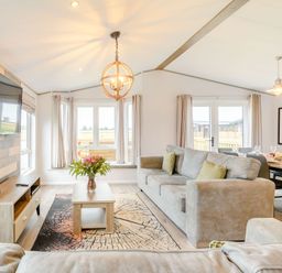 A living room with a sofa and television at Beech Waterside Spa (Pet) Carlton Miniott near Thirsk