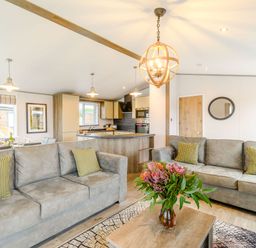 A living room with sofas and a kitchen area at Beech Waterside Spa (Pet) Carlton Miniott near Thirsk