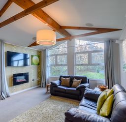 A living room with sofa and television at Cherry Tree in Carlton Miniott near Thirsk