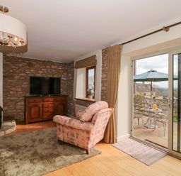 A living room with a television and sofa at Daisy Bank in Maugersbury near Stow-On-The-Wold