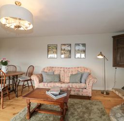 A living room with a sofa and dining table at Daisy Bank Maugersbury near Stow-On-The-Wold