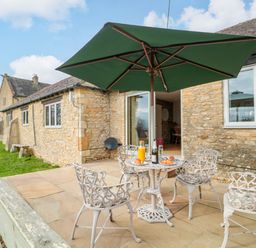 An outdoor patio with a table and chairs at Daisy Bank Maugersbury near Stow-On-The-Wold