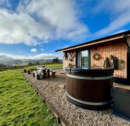 An outdoor area with a hot tub and wooden seating at Harriet in Llangurig