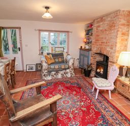 A living room with a couch and fireplace at The Hare & the Bumblebee Cottage