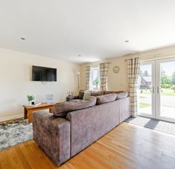 A living room with a sofa and television at Sage Lodge near Brigg