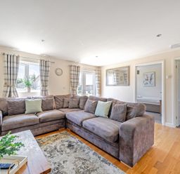 A living room with a sofa, windows, and curtains at Sage Lodge near Brigg